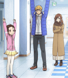 a man in a blue jacket is standing in a hallway with his arms up