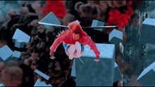 a person in a red jacket is flying through the air with a helicopter in the background .