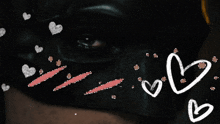a close up of a person wearing a black mask with hearts around it