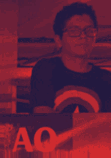 a man wearing glasses and a rainbow shirt stands in front of a sign that says ao