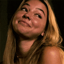 a close up of a woman 's face making a funny face