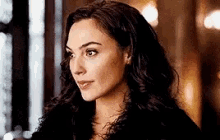 a close up of a woman 's face with dark hair and a black coat .