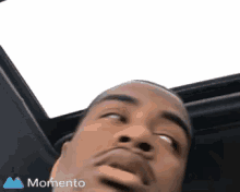 a man is sitting in a car looking up at the skylight