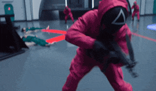 a man in a pink suit is holding a gun in front of a group of people