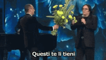 Renato Zero Carlo Conti Fiori Lanciare Non Li Voglio Te Li Tieni GIF - Renato Zero Carlo Conti Flowers GIFs