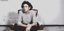 a man with curly hair is sitting in a chair with a caption that says mattysteeth on it