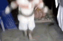 a blurry picture of a person in a white costume walking down a street .