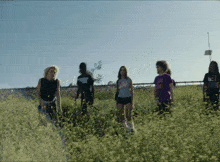 a group of people walking through a field with one wearing a t-shirt that says ' i love you '