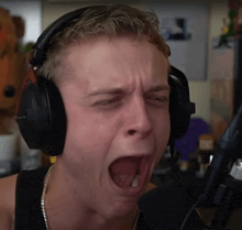 a man wearing headphones making a funny face with his mouth open