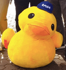 a stuffed yellow duck with a blue hat that says smg4 on it