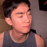 a close up of a man 's face with a tank top that says ' reebok ' on it