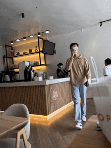 a man walks past a counter that says five brew on it