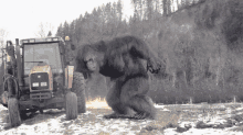 a large gorilla is standing in front of a tractor that says eureka
