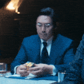 a man in a suit and tie is holding a rubik 's cube