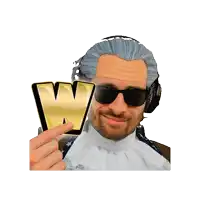 a man wearing sunglasses and headphones holds up a gold w