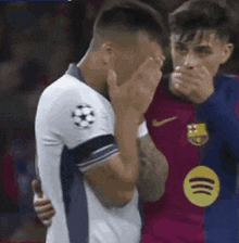 two soccer players are covering their mouths with their hands during a match .