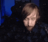 a close up of a person 's face with a blue light behind them