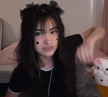 a girl with black stars on her face is giving a thumbs up