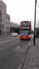 a red double decker bus with the number 222 on the front is driving down a street