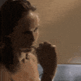 a woman is brushing her teeth in front of a mirror .