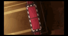 a red square with white lines on it is on a brown floor