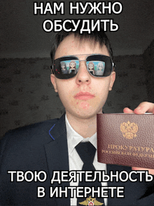 a man in a suit and tie holds up a russian passport
