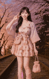 a girl in a pink dress stands on train tracks