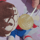 a person is holding a lollipop next to a stuffed animal with the letter s on it
