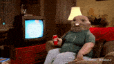 a person is sitting on a couch holding a can of coca cola