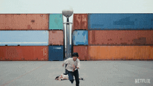 a man running in front of a stack of shipping containers with netflix on the bottom