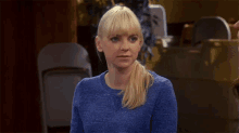 a woman in a blue sweater is looking at something