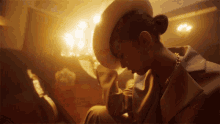 a woman wearing a hat and a necklace is looking down