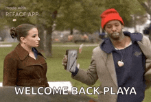 a man and a woman are standing in a park .