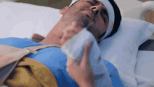 a man laying in a hospital bed with a bandage on his head