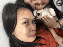 a woman holds a small white dog in her arms