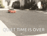 a red toy car is driving down a street with the words quiet time is over written on the bottom