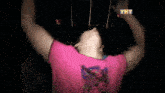 a man in a pink shirt is making a heart with his hands in front of the tht logo