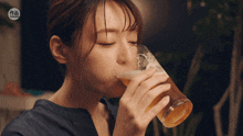 a woman drinking a glass of beer with a sticker that says ' taiwanese ' on it