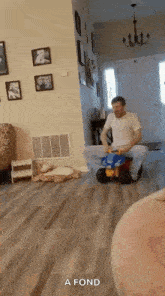 a man is riding a toy car in a living room .
