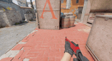 a person holding a red gun in front of a building with the letter a on it