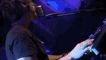 a man in a black shirt is singing into a microphone