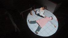 a woman in a pink apron laying on the floor