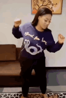 a woman wearing a blue sweater that says " blind for love " is dancing