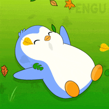 a blue and white penguin is laying on the grass