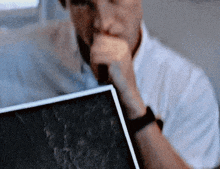 a man in a white shirt is holding a piece of paper in his hand