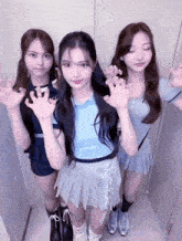 three girls standing next to each other with one wearing a blue shirt that says ' eee ' on it