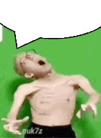 a man without a shirt is screaming in front of a green screen .