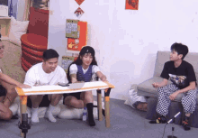 a group of people are sitting around a table with a vending machine that says ' ken ' on it