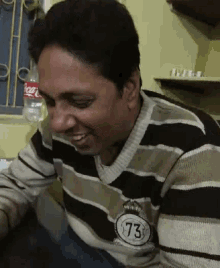 a man wearing a striped sweater with the number 73 on his chest