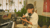 a man is writing in a book while playing a guitar and the words it will be a kind of spice in our long journey